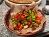 A close-up shot of a delicious bowl of spicy chicken with chili peppers and green peppers