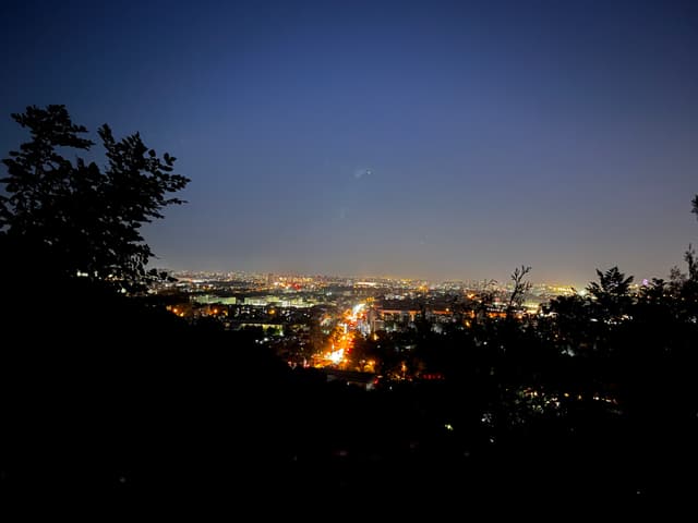 远眺城市夜景，灯火阑珊，远处天际线依稀可见。