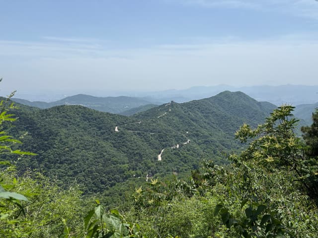 Layered forested mountain ridges beneath a hazy blue horizon
