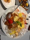 冰镇水果拼盘，包含草莓、菠萝、橘子等水果，装饰有薄荷叶。